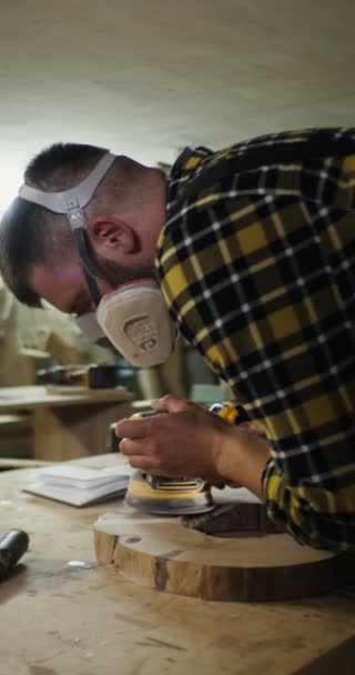 Man van Europese verschijning in beschermende koptelefoon en een masker verwerkt een hout — Stockvideo