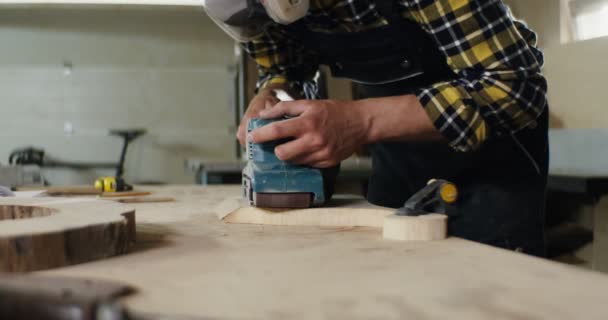 戴着防护性耳机和面罩的欧洲男子加工木料 — 图库视频影像