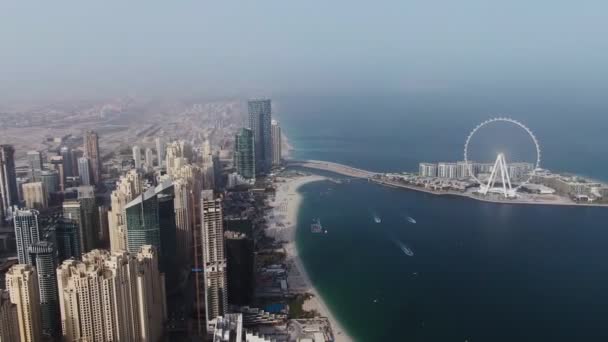Függőleges pásztázás egy négykopterből. Légi felvétel a strandról és a felhőkarcolókról, Dubai. — Stock videók