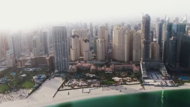 Függőleges pásztázás egy négykopterből. Légi felvétel a strandról és a felhőkarcolókról, Dubai. — Stock videók