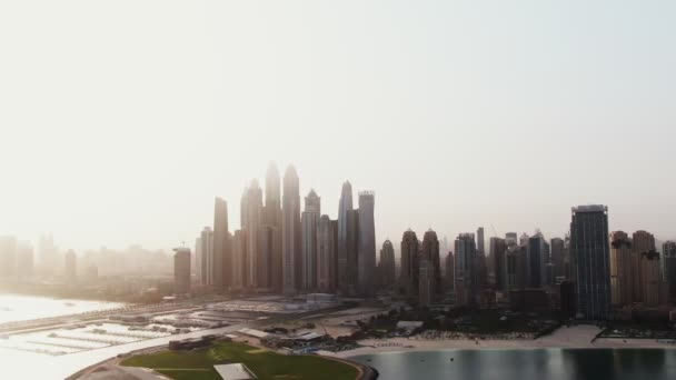 Függőleges pásztázás egy négykopterből. Légi felvétel a strandról és a felhőkarcolókról, Dubai. — Stock videók