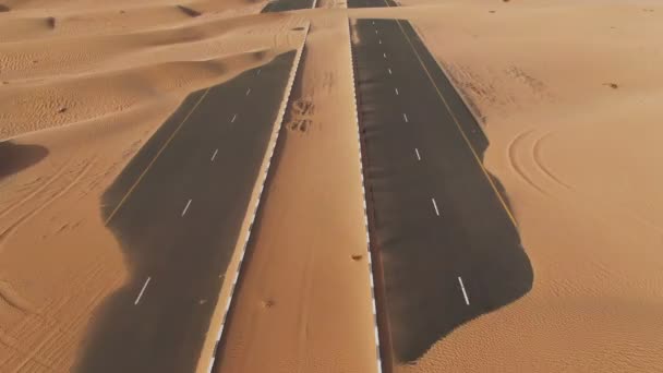 Vzdušný pohled na pouštní silnici pohřbenou písečnými dunami. Dubaj, SAE. — Stock video