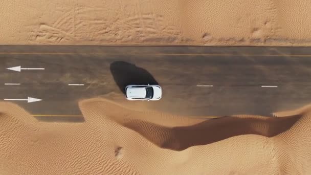 Panning vertikal dari quadcopter. Mobil putih mengemudi di jalan di padang pasir — Stok Video