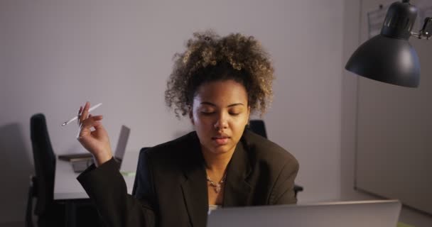 Afro ragazza in giacca colpi di scena penna in mano prende appunti in notebook in — Video Stock