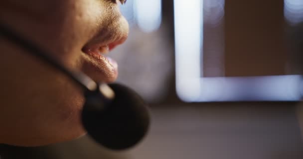 Chica africana con auriculares y micrófono habla activamente, de cerca — Vídeos de Stock