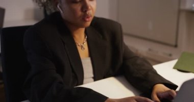 Ofisteki bilgisayarın başında afro saçlı güzel esmer bir kız çalışıyor.