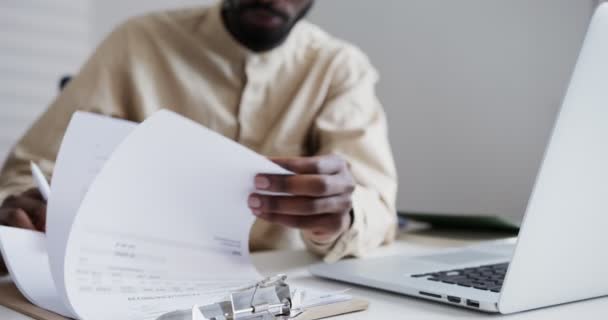 Homme noir en chemise feuillets à travers un carnet de notes dans le bureau — Video