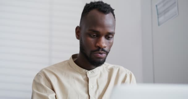 Noir homme avec court afro coiffure dactylographie ordinateur portable parler et secouer la tête — Video