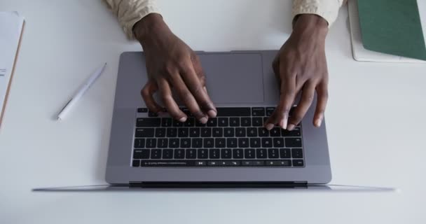 Чорний хлопець повільно друкує на ноутбуці крупним планом — стокове відео