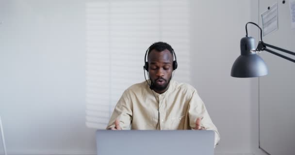 Negro chico lleva auriculares con micrófono, gritos, juramentos y tipos — Vídeo de stock