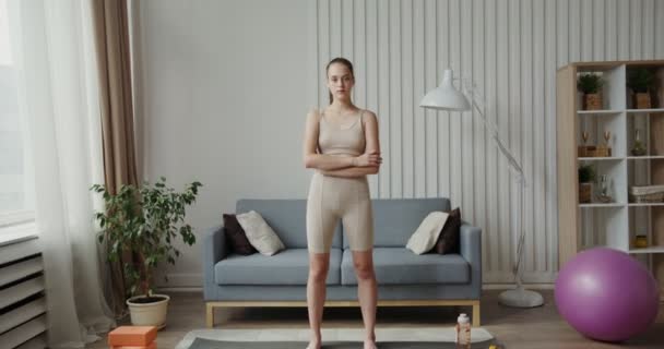 Evropská dívka ve sportovním oblečení se dívá na kameru, paže složené na hrudi — Stock video
