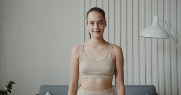 Menina europeia com o cabelo reunido vestido de sportswear sorrindo para a câmera — Vídeo de Stock