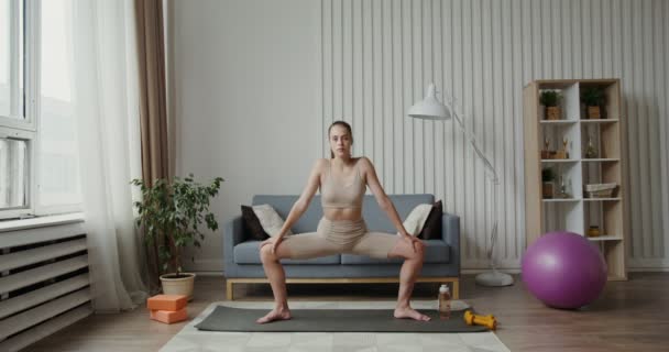Європейська дівчина, одягнена в спортивне лаяння, робить спідницю з нахилом плеча. — стокове відео