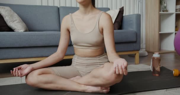Fille européenne en vêtements de sport assis dans une position de lotus avec les yeux fermés — Video