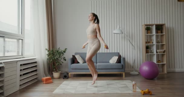 European girl dressed in sportswear, jumping rope from foot to foot — Stock Video