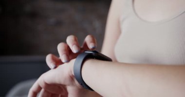 Açık tenli bir kız akıllı bir saat ya da spor bilekliği kullanır.