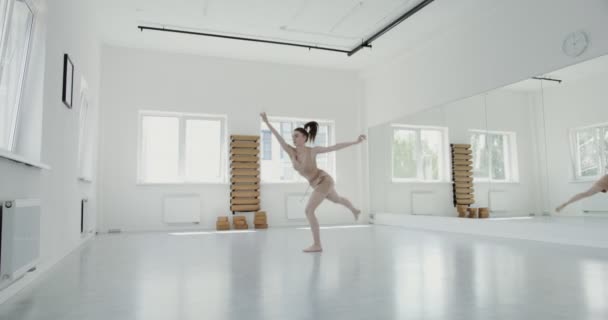Ragazza europea in abbigliamento sportivo fare balletto ritmico affonda e salta — Video Stock
