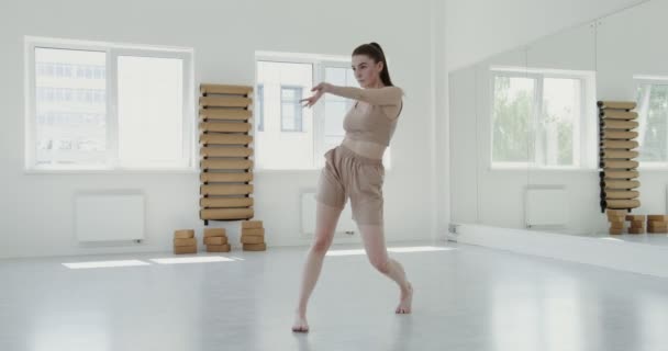 Európai lány sportruházatban, aki ritmikus balettütéseket csinál — Stock videók