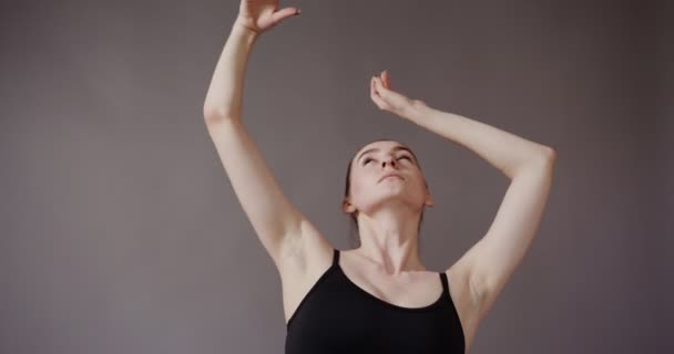 Meisje met een mooie huid in zwarte top, maakt soepele bewegingen met haar — Stockvideo