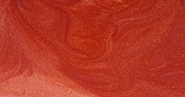 Czerwona błyszcząca woda powoli wpada w piękne abstrakcyjne wzory. — Wideo stockowe