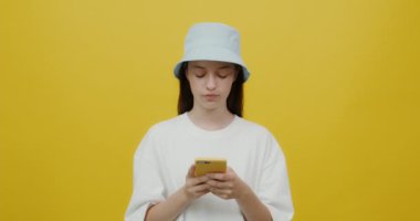 Panama şapkalı Avrupalı genç bir kadın gülümsüyor, cep telefonuyla sohbet ediyor.