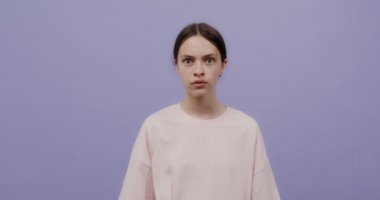 Genç bir kadın ciddi bir şekilde dinler, sonra korkar ve şok olur.