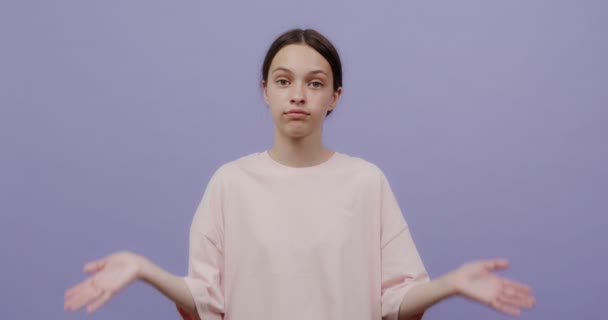 Молодая женщина европейского образца с удивлением раздвигает руки и пожимает плечами — стоковое видео