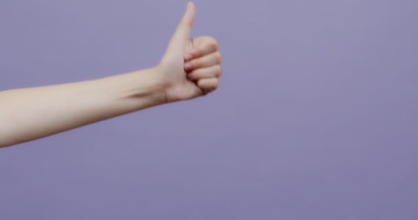 One female hand with fair skin appears and gives a thumbs up — Stock Video