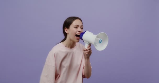 Una joven grita en un altavoz y agita sus brazos como una animadora — Vídeos de Stock