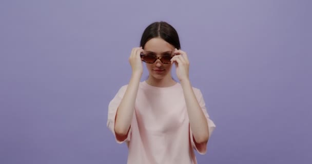 Μια νεαρή γυναίκα φοράει λεοπαρδαλέ γυαλιά ηλίου και χαμόγελα — Αρχείο Βίντεο