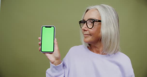 Une femme adulte tient un téléphone avec un écran à la caméra — Video