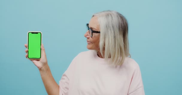 Una donna adulta tiene un telefono con uno schermo alla macchina fotografica — Video Stock