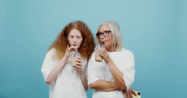 En vuxen kvinna och en ung flicka dricker cocktails, skrattar och pratar. — Stockvideo