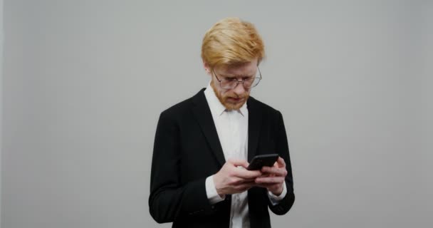 Een serieuze man begint heel gelukkig te worden na het lezen van iets over de telefoon — Stockvideo