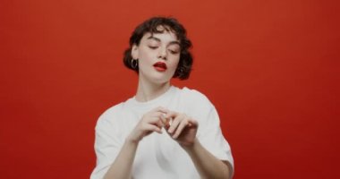 Kırmızı rujlu bir esmer ritmik bir hareketle dans eder