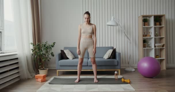 Chica europea vestida con ropa deportiva, haciendo ejercicios para calentar el cuello — Vídeo de stock