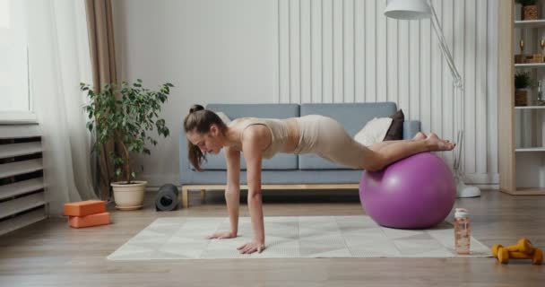 Menina europeia vestida de sportswear fazendo exercícios de força com bola — Vídeo de Stock