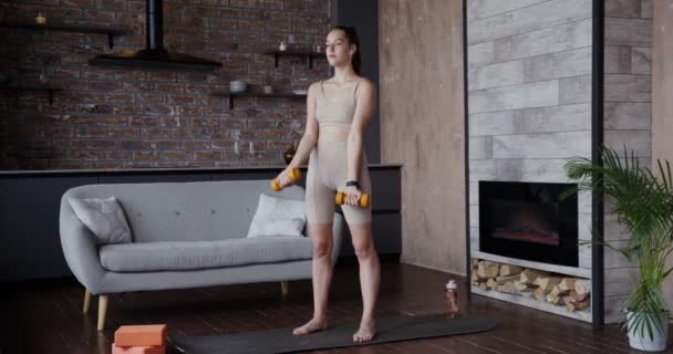 Menina europeia vestida de sportswear fazendo exercícios com halteres — Vídeo de Stock