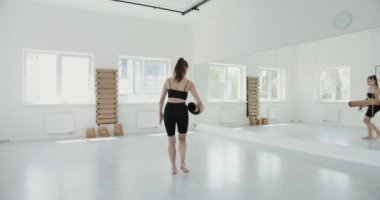 Spor giyim sektöründe Avrupalı bir kız jimnastik salonuna gelir ve ısınmaya başlar.