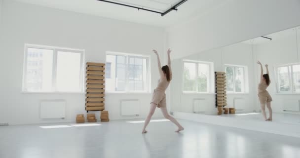 Chica europea en ropa deportiva haciendo saltos de ballet rítmicos — Vídeo de stock