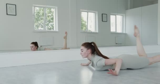 Chica europea en ropa deportiva haciendo saltos de ballet rítmicos — Vídeos de Stock