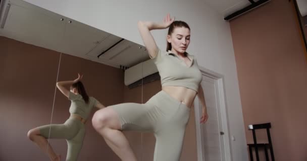 Європейська дівчина зі спортивного одягу займається гімнастикою. — стокове відео