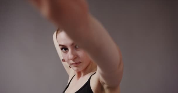 Menina com pele clara em top preto, faz movimentos suaves com as mãos — Vídeo de Stock