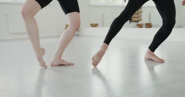 A man and a woman with fair skin dance rhythmically barefoot, legs close up — Stock Video