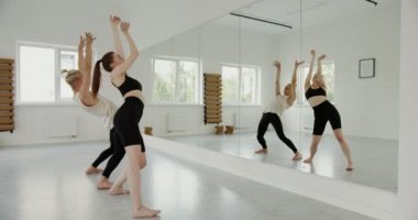 Açık tenli kız ve Avrupalı görünümlü adam aynaya dönüp dans ediyorlar.