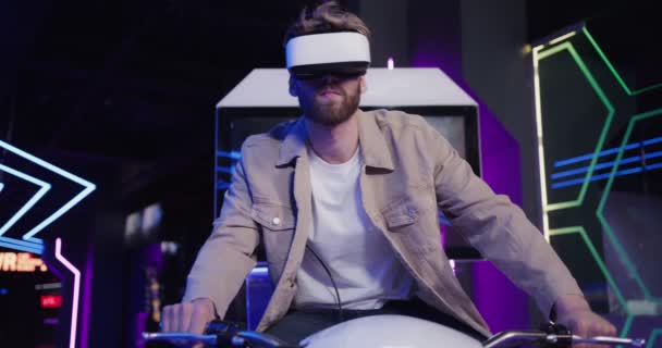 Człowiek z brodą w okularach wirtualnej rzeczywistości kontroluje motocykl — Wideo stockowe