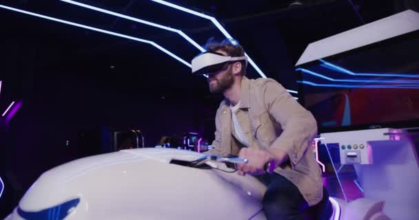 A man with a beard in virtual reality glasses controls a motorcycle — Stock Video