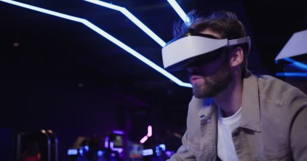 Een man met een baard in virtual reality bril bestuurt een motorfiets. — Stockvideo