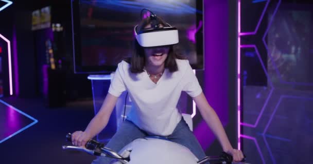 Mujer europea en gafas de realidad virtual controla una motocicleta — Vídeos de Stock