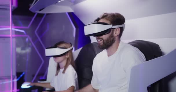 Um homem e uma menina vestindo óculos de realidade virtual em uma atração 5D — Vídeo de Stock